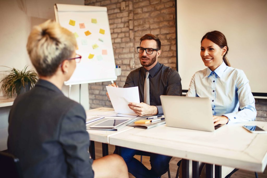 HR professionals interviewing a candidate in an office, representing the use of chatbots in recruitment to streamline candidate screening and improve hiring efficiency.