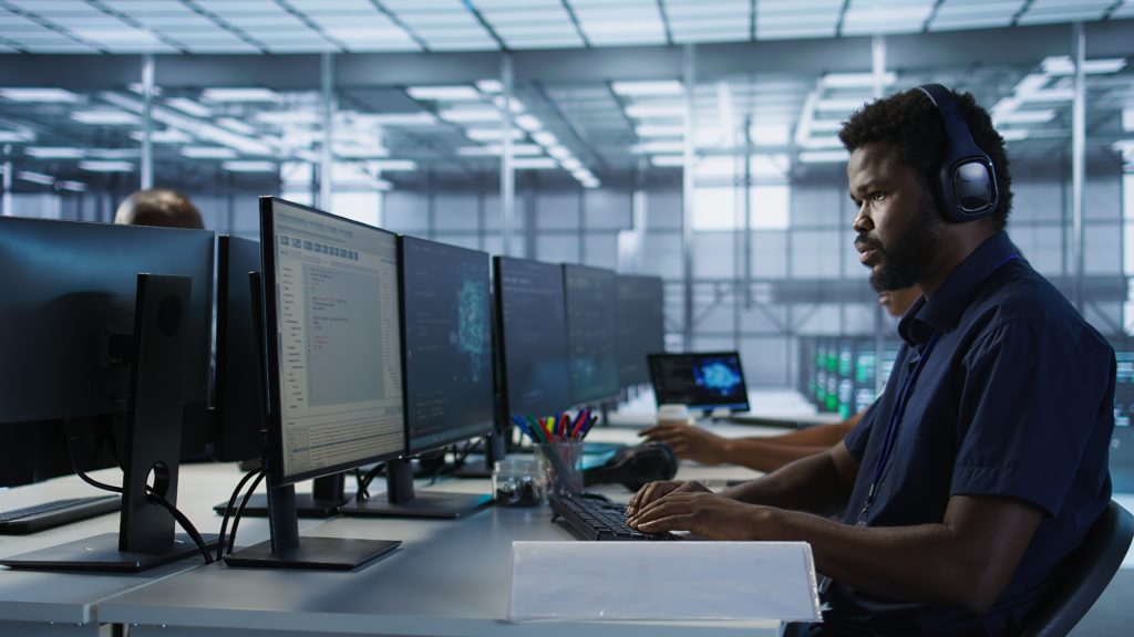 engineer in server room in front of displays