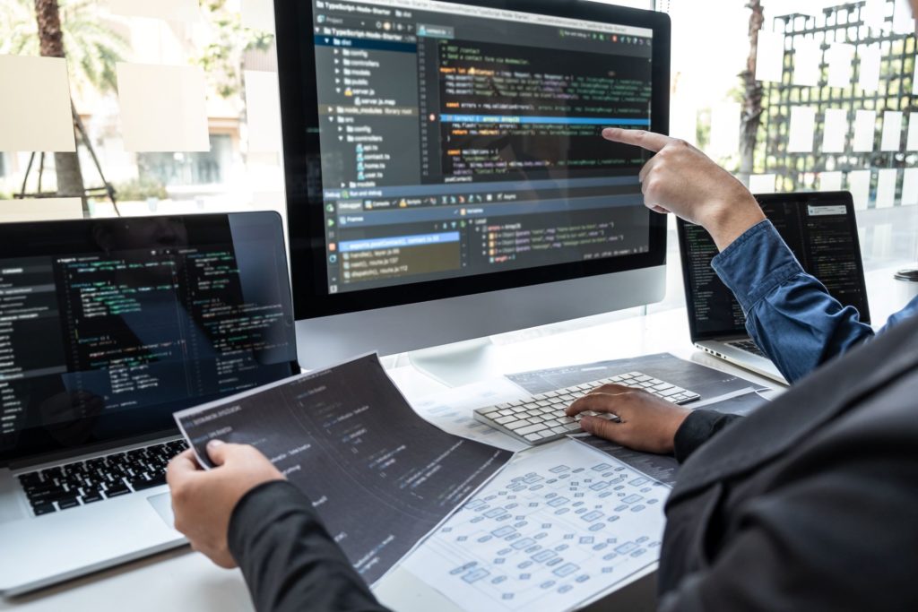 IT professionals writing a code on the workstation in the office_UK software development