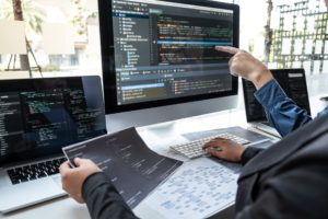 IT professionals writing a code on the workstation in the office_UK software development