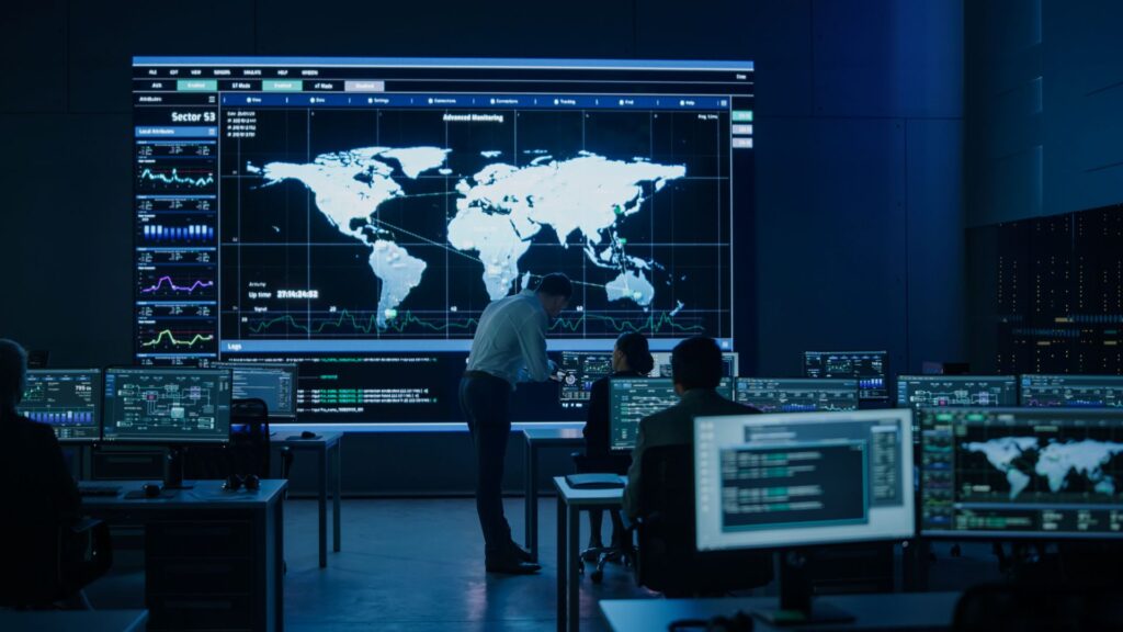 Digital Sovereignty Solutions. Cybersecurity team working in a room with big screen display showing infographics and world map data