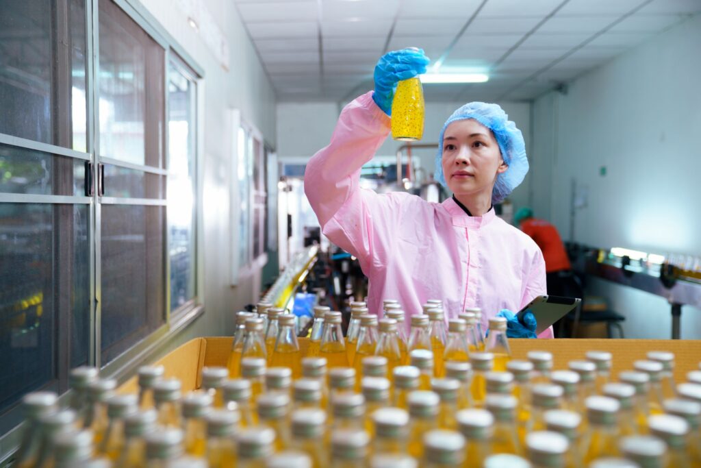 Quality control inspector monitoring juice production line in agri-food factory. Digital product passport in agri-food