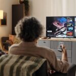 People watching tv together relaxing at home.